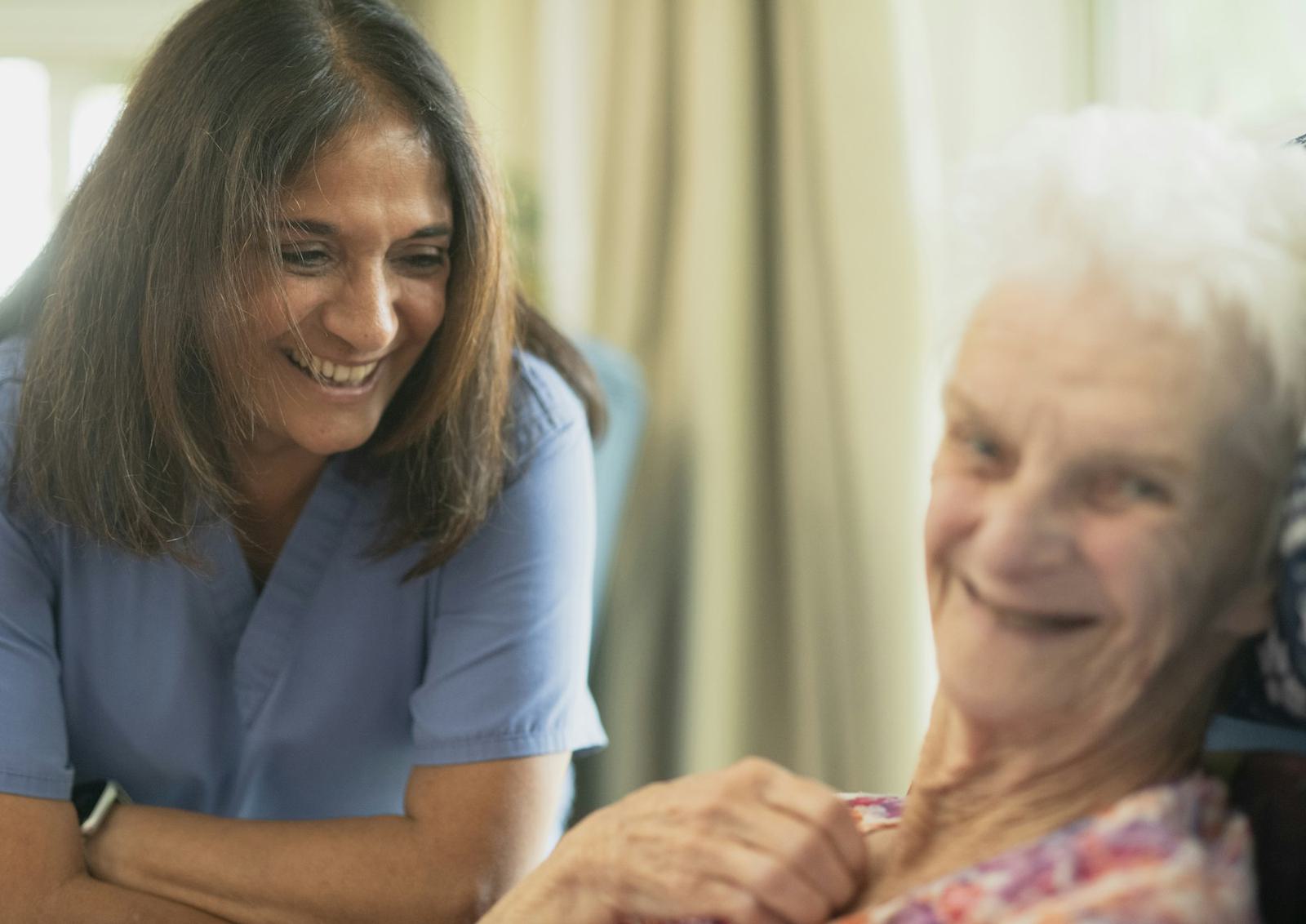 A carer sharing a laugh with an older woman